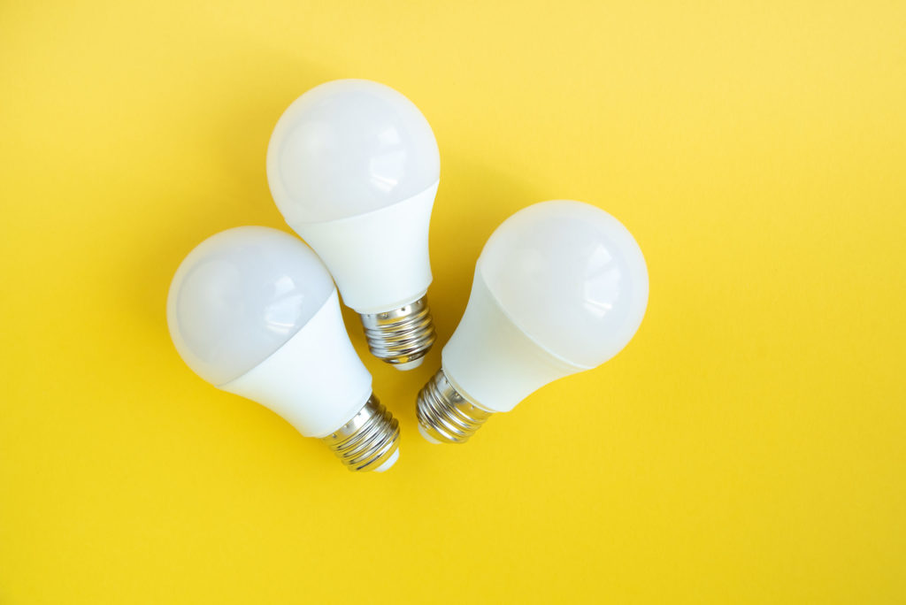Three LED light bulbs on yellow background. energy saving concept